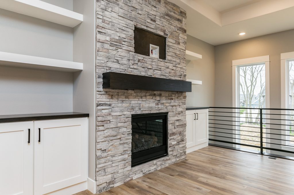 stone fireplace with built in cabinet and shelves