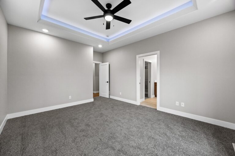 bedroom with tray ceiling and bathroom next to it