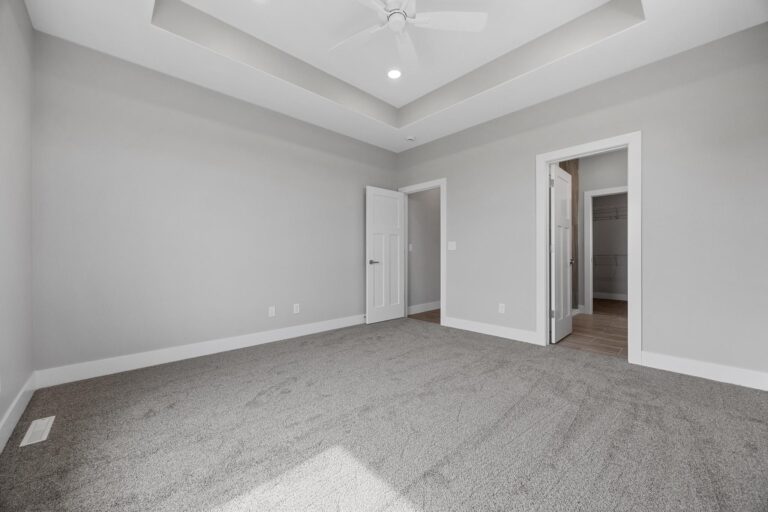 bedroom with tray ceiling and bathroom next to it