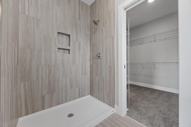 tiled shower next to walk in closet